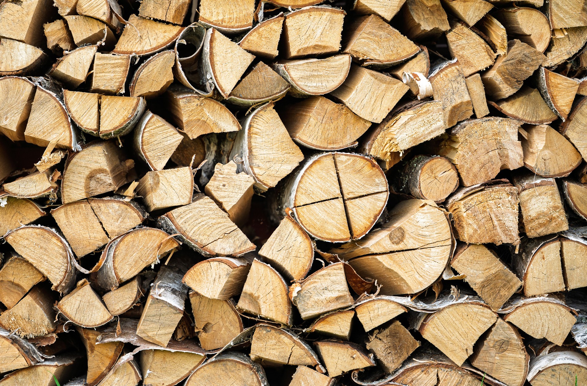 Firewood background, stack of chopped birch logs, natural wooden texture or pattern, preparation for winter heating season, sustainable energy and fuel theme