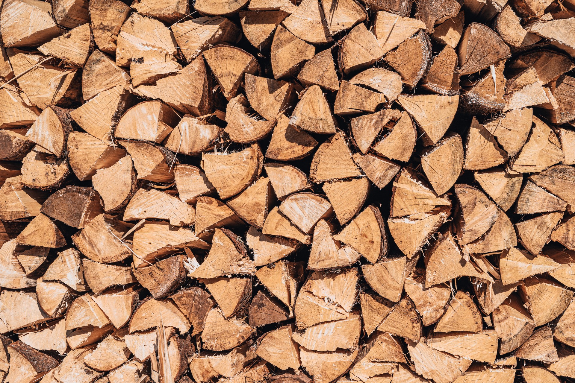 Stacked firewood in neat pile, natural background